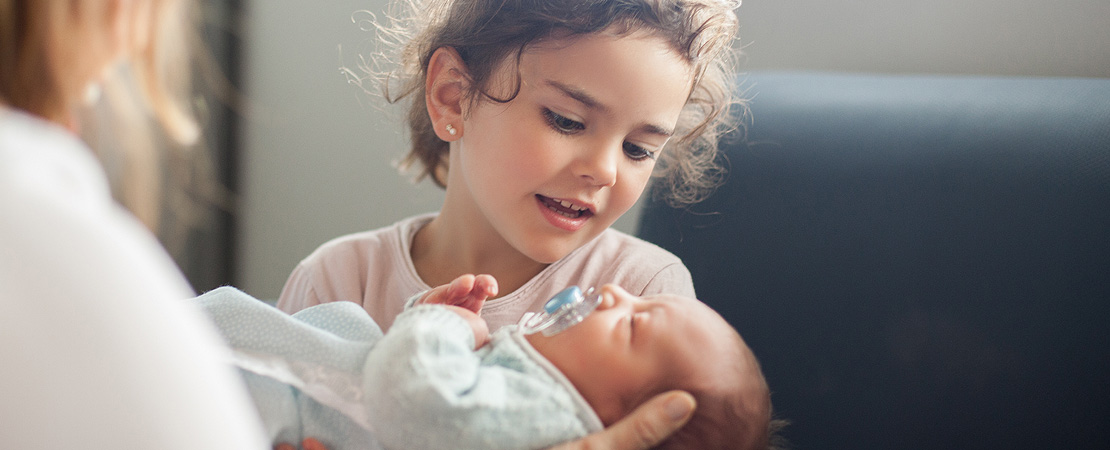 Young child looking at a baby