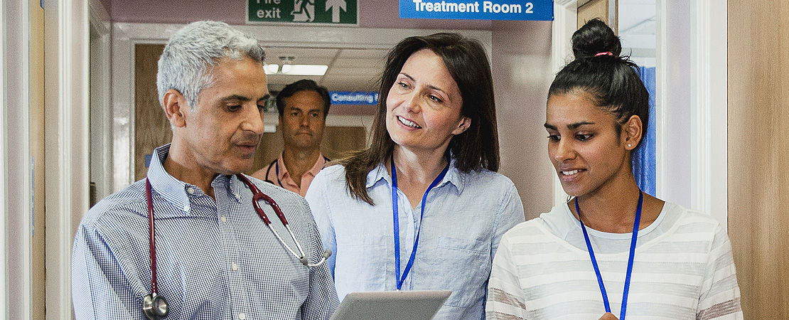Three doctors walking together along a hospital corridor
