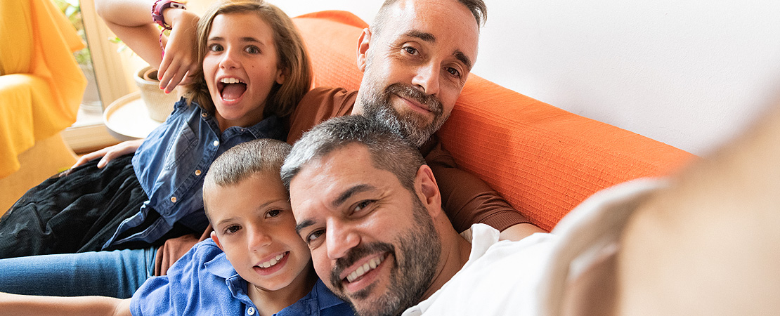 A young family smiling on sofa