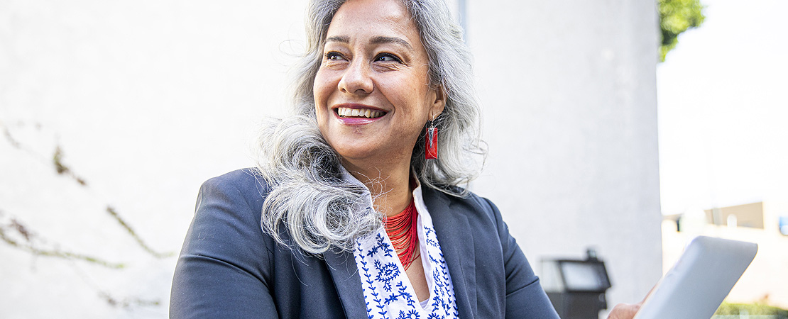 Woman smiling using a hand-held device