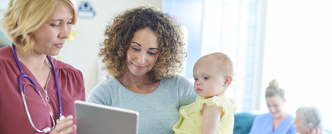 femaie doctor talking to a lady with a baby