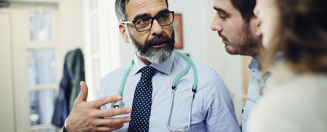 A doctor talking to two people