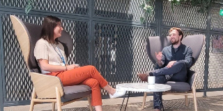 Two work colleagues seated and chatting