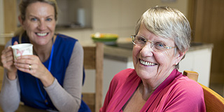 Elderly lady and carer smiling