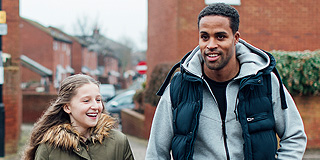 Man and young girl walking and smiling