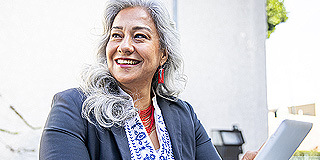 Woman smiling using a hand-held device